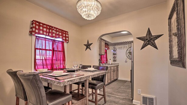 A dining area with a marble table, leather chairs, and a chandelier. - Downtown Cedar City House < 1/2 Mi to SUU Campus! (Cedar City)