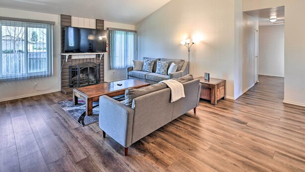 A living room with a fireplace, a sofa, a coffee table, and a TV mounted on the wall.