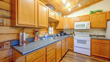 A kitchen with wooden cabinets, a granite countertop, a microwave, and a stove.