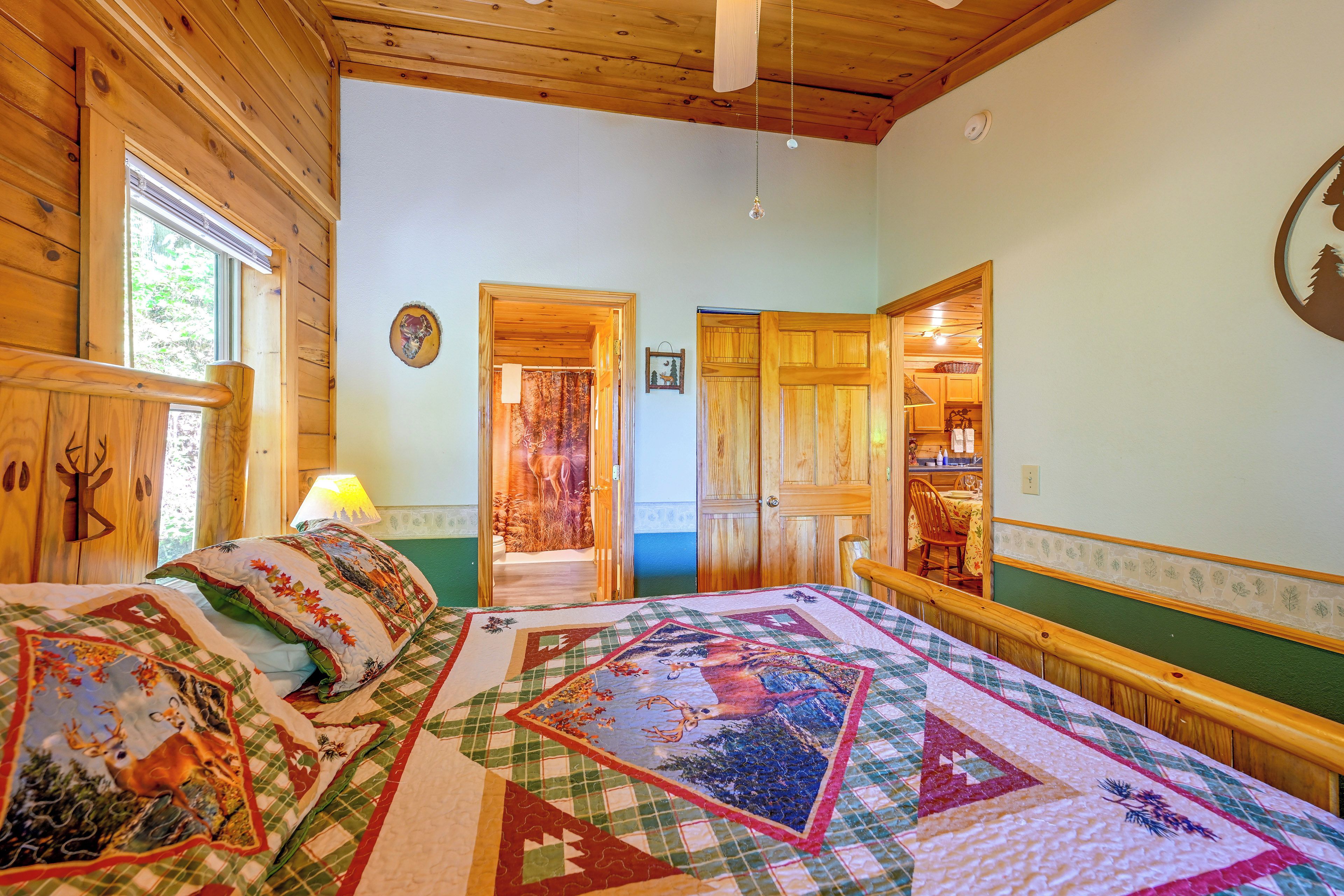 Quarto aconchegante com uma cama grande, paredes de madeira e vista para o exterior através de uma janela.