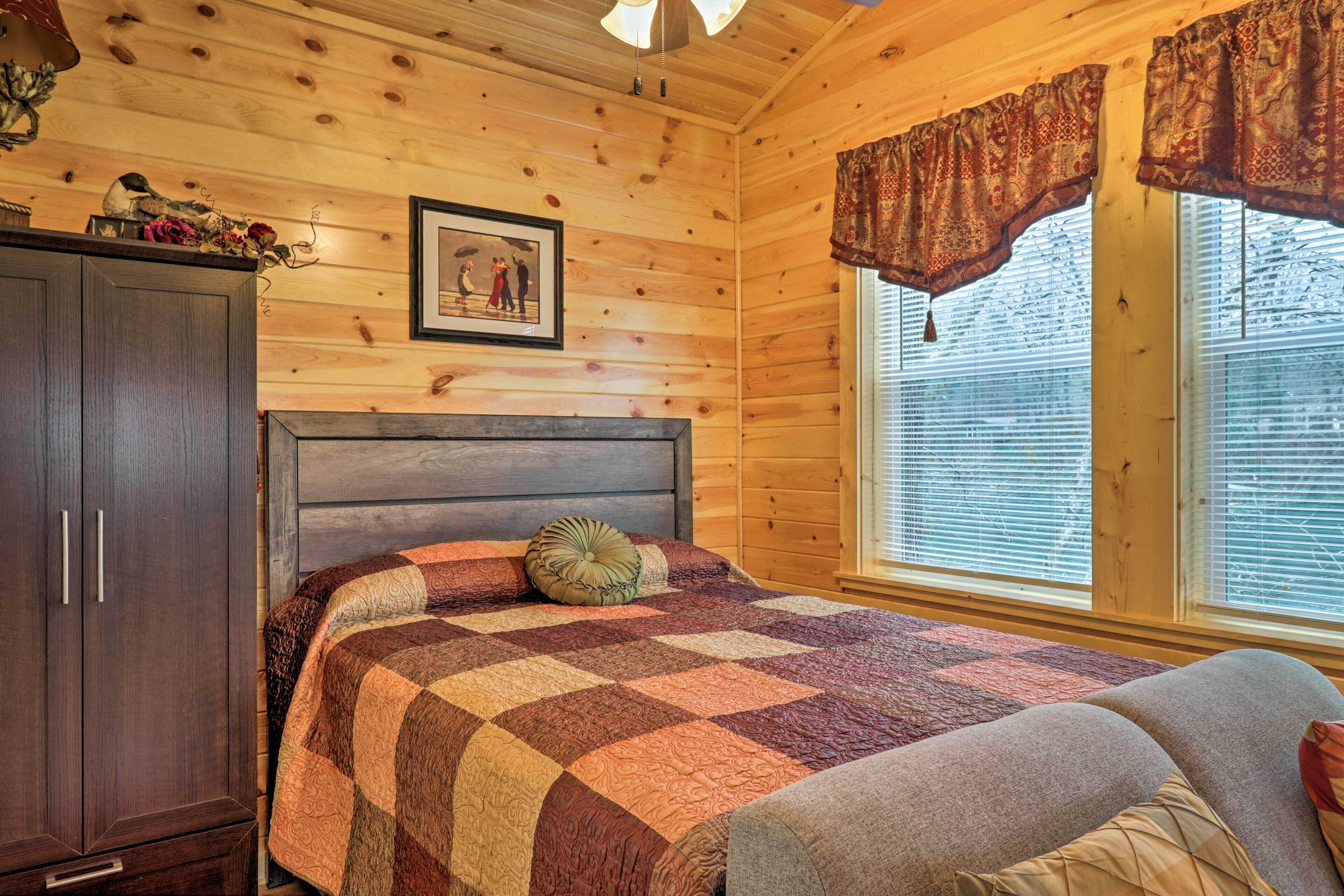 A wooden cabin bedroom with a bed, a wardrobe, and a window with blinds.
