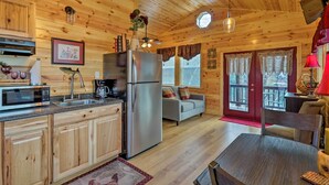 A wooden cabin interior with a kitchen, dining area, and a cozy living room. - Cozy Heber Springs Cabin w/ Deck & Dock! (Heber Springs)