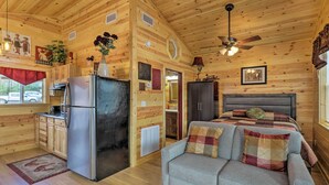 A cabin interior with a kitchenette, a bed, and a sofa. - Cozy Heber Springs Cabin w/ Deck & Dock! (Heber Springs)