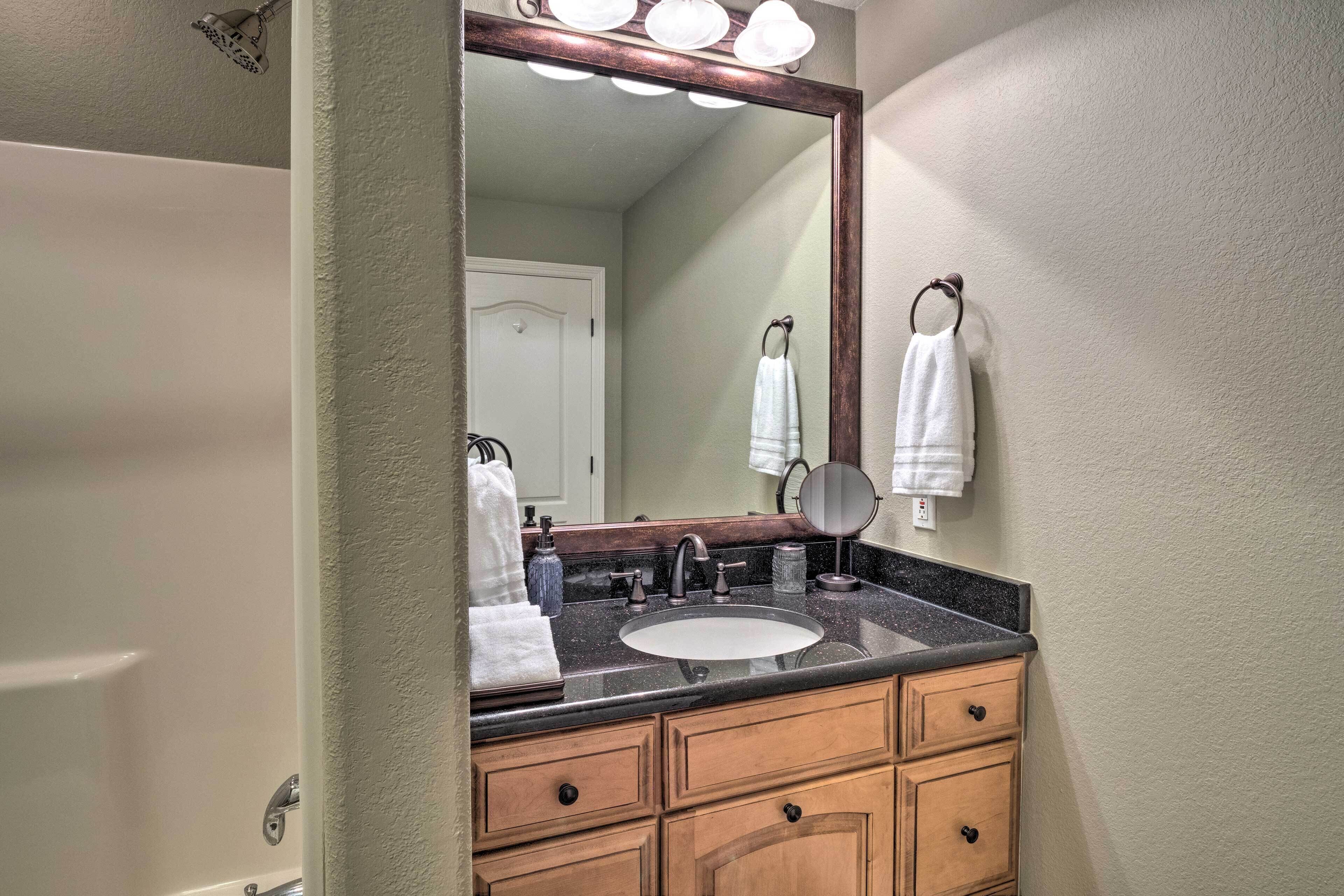 A bathroom with a sink, mirror, and towel rack.