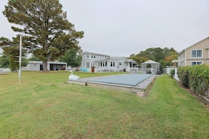 A residential area with a large lawn, a gazebo, and a swimming pool.