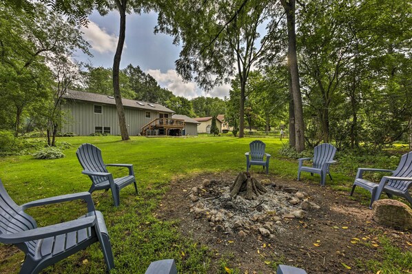 A grassy outdoor area with a fire pit and Adirondack chairs. - Lake Nagawicka Home - 2 Blocks to Boat Launch (Delafield)