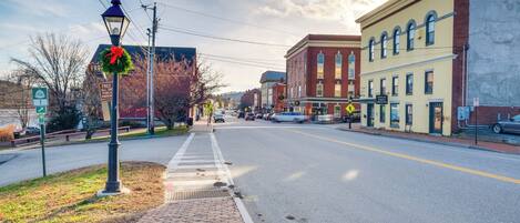 A street with brick sidewalks, a lamp post, and a building with a yellow facade.