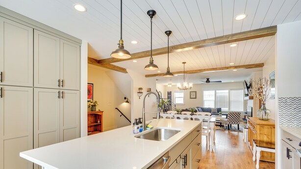 A spacious kitchen with a large island, wooden beams on the ceiling, and pendant lighting. - Spacious Townhome ~ 7 Mi to Deer Valley Resort! (Heber City)