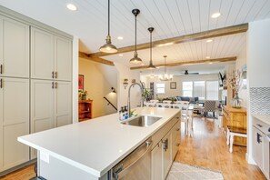 A spacious kitchen with a large island, wooden beams on the ceiling, and pendant lighting. - Spacious Townhome ~ 7 Mi to Deer Valley Resort! (Heber City)