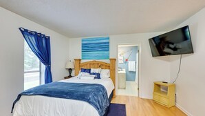 A bedroom with a bed, a TV, a wooden nightstand, and a window with curtains. - Lakefront Home w/ Kayaks & Dock in Hot Springs! (Hot Springs)