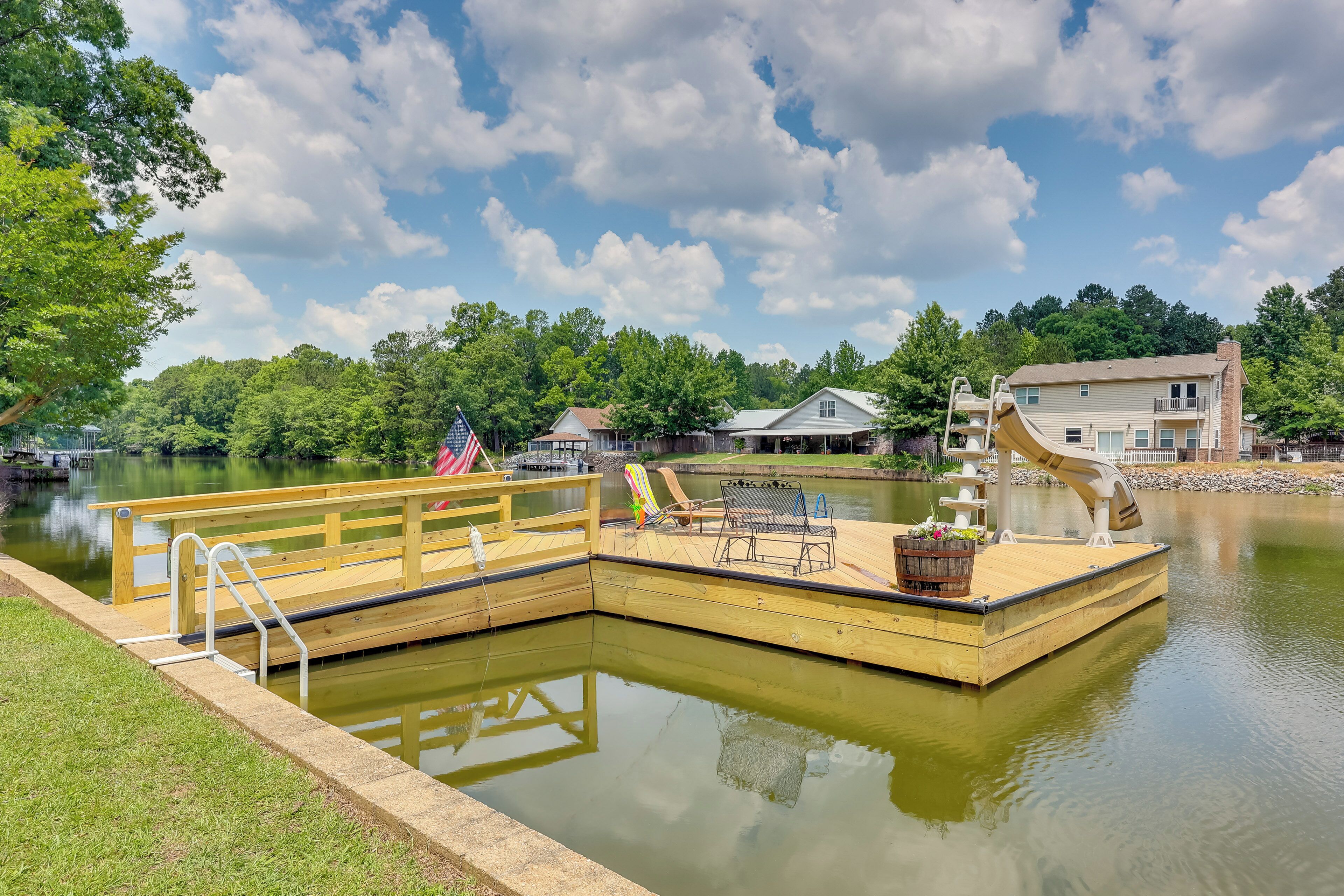 A dock with a small boat, a picnic table, and a bench.