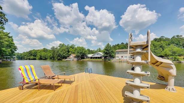 A wooden deck with lounge chairs and a water slide. - Lakefront Home w/ Kayaks & Dock in Hot Springs! (Hot Springs)
