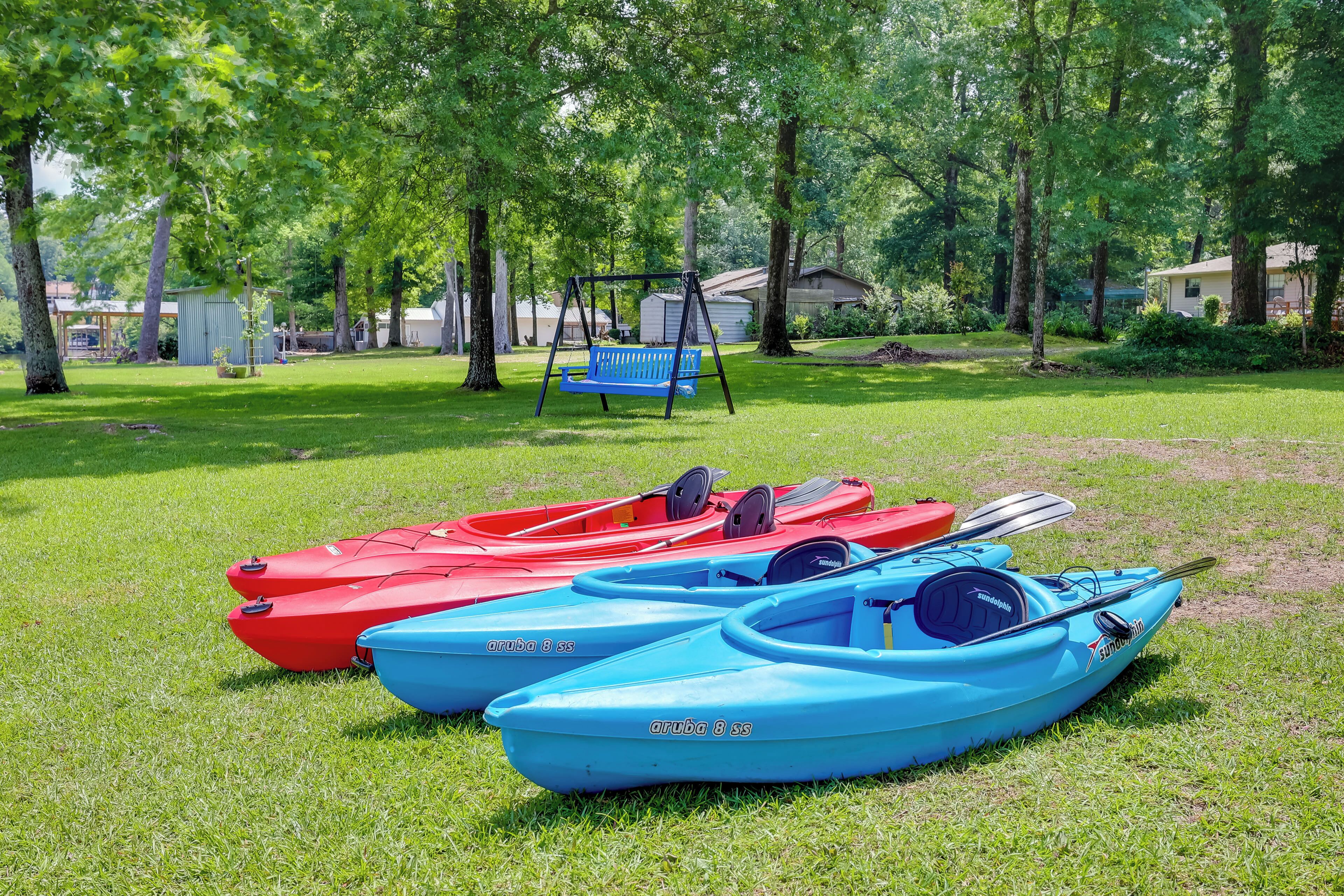Une zone herbeuse avec des kayaks et une balançoire.