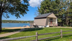A lodge with a small porch and a view of a lake.