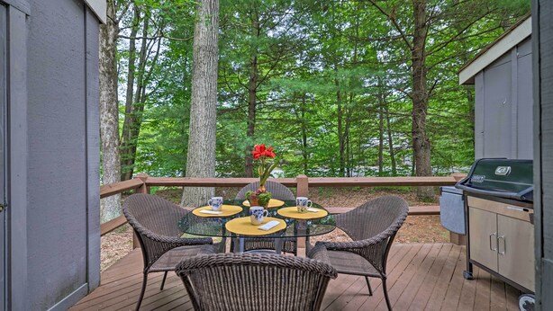 A deck with wicker chairs and a glass table, a grill, and a view of a forest. - Mountain Retreat Near Jack Frost & Big Boulder (White Haven)