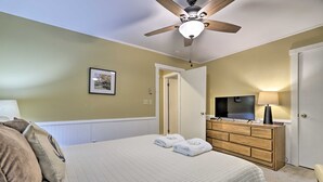 A hotel room with a bed, a ceiling fan, a dresser, a television, and a door. - Poconos Retreat By Jack Frost Wooded Escape (White Haven)