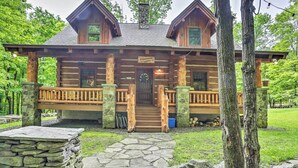 Eine Blockhütte mit Steinfundament, Holzveranda und einem Schild mit der Aufschrift 'Auburnhurd Lodge'.