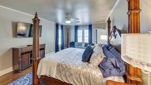 A spacious bedroom with a large bed, a ceiling fan, a wooden dresser, and a television on the wall. - 'the Pink Azalea' - Tyler Home w/ Yard + Patio! (Tyler)