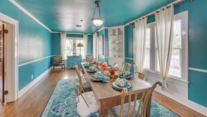 A dining room with teal walls, a wooden table set for six, and a chandelier. - 'the Pink Azalea' - Tyler Home w/ Yard + Patio! (Tyler)