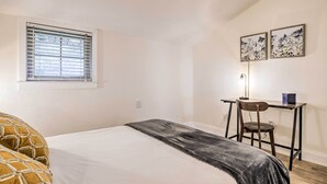 A bedroom with a bed, a desk, and a chair. - Ideally Located & Updated Chapel Hill Apartment! (Chapel Hill)