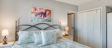 A bedroom with a bed, nightstands, a painting, and a wardrobe.