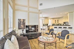 A modern living room with a large flat-screen TV, a sofa, and a coffee table. - Han Solo's Hideout Luxe Houston Home w/ Pool! (Houston)