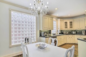 A kitchen with white cabinets, a chandelier, and a dining table with chairs. - Han Solo's Hideout Luxe Houston Home w/ Pool! (Houston)
