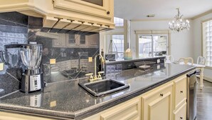 A kitchen with a granite countertop, a built-in sink, a double electric stove, and a large window. - Han Solo's Hideout Luxe Houston Home w/ Pool! (Houston)