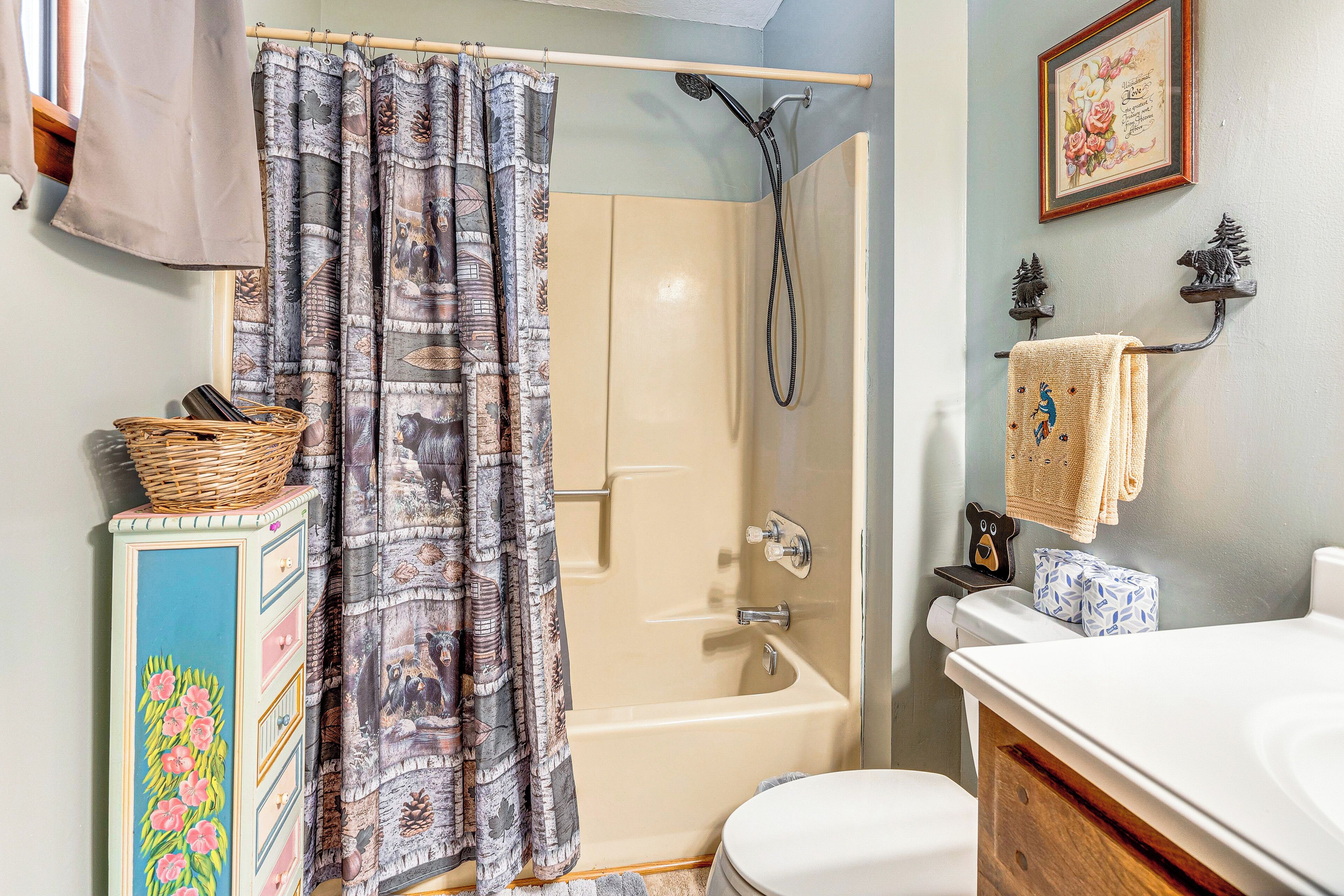 A bathroom with a shower, toilet, and a vanity with a sink.