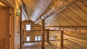 A spacious attic room with wooden beams, a wooden floor, and a window providing natural light. - Stunning Mountain Views: Livingston Cabin w/ Deck! (Livingston)