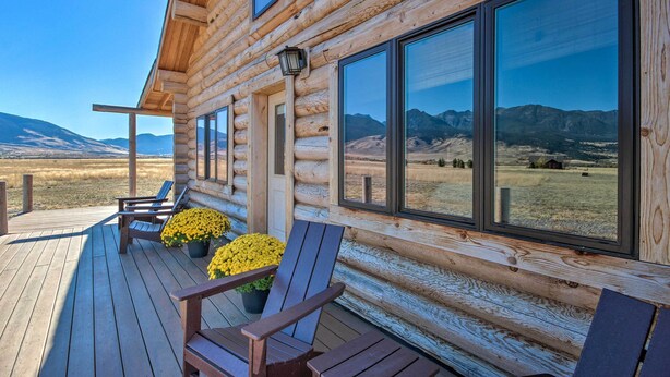 A log cabin with a wooden deck, large windows, and outdoor seating. - Stunning Mountain Views: Livingston Cabin w/ Deck! (Livingston)