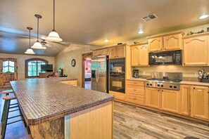 A spacious kitchen with a large island, wooden cabinets, stainless steel appliances, and pendant lighting. - Kingston House w/ Fire Pit, Short Walk to Lake! (Kingston)