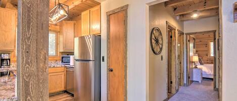 A modern kitchen with wooden cabinets, stainless steel appliances, and a marble countertop.