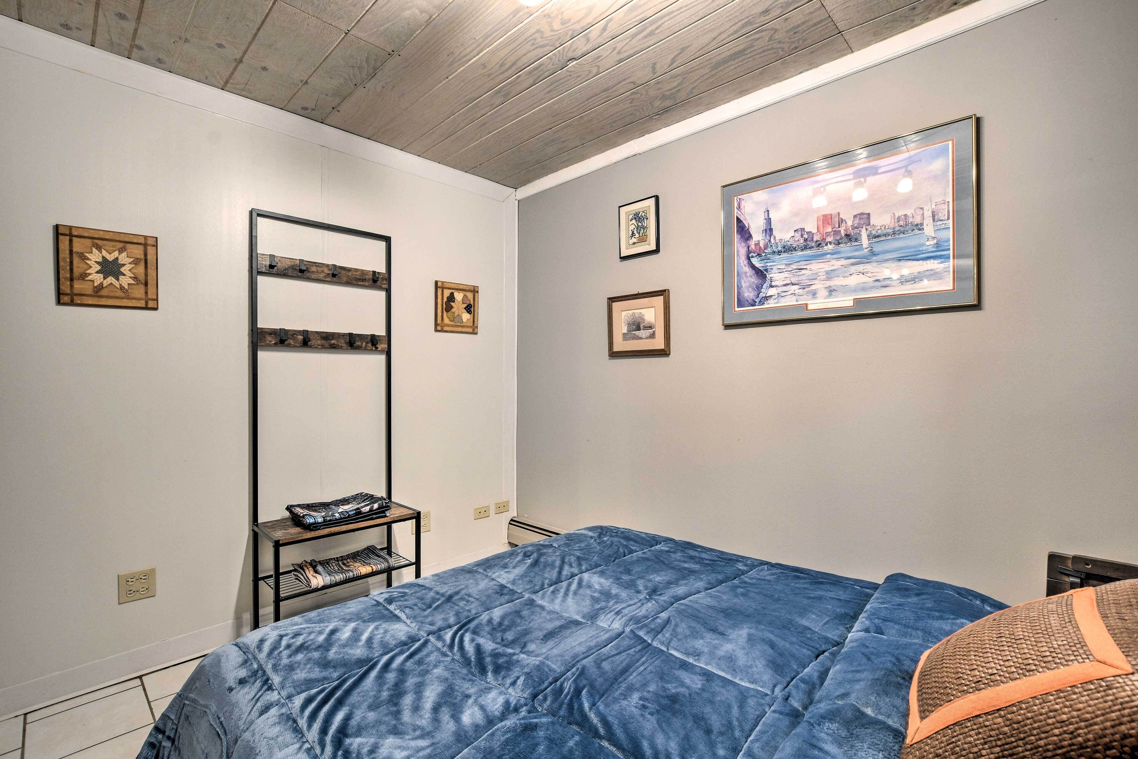A bedroom with a bed, a wall-mounted shelf, and a cityscape painting.