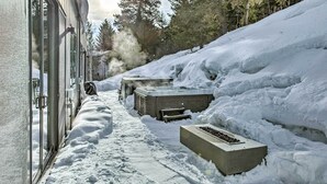 Un sentier enneigé menant à un bâtiment qui comprend un espace sauna.