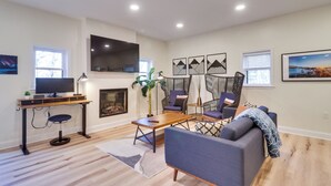 A modern living room with a flat-screen TV, a wooden desk, a blue sofa, and a patterned chair. - Mtn Retreat w/ EV Charger Near Bryce Ski & Golf (Mount Jackson)