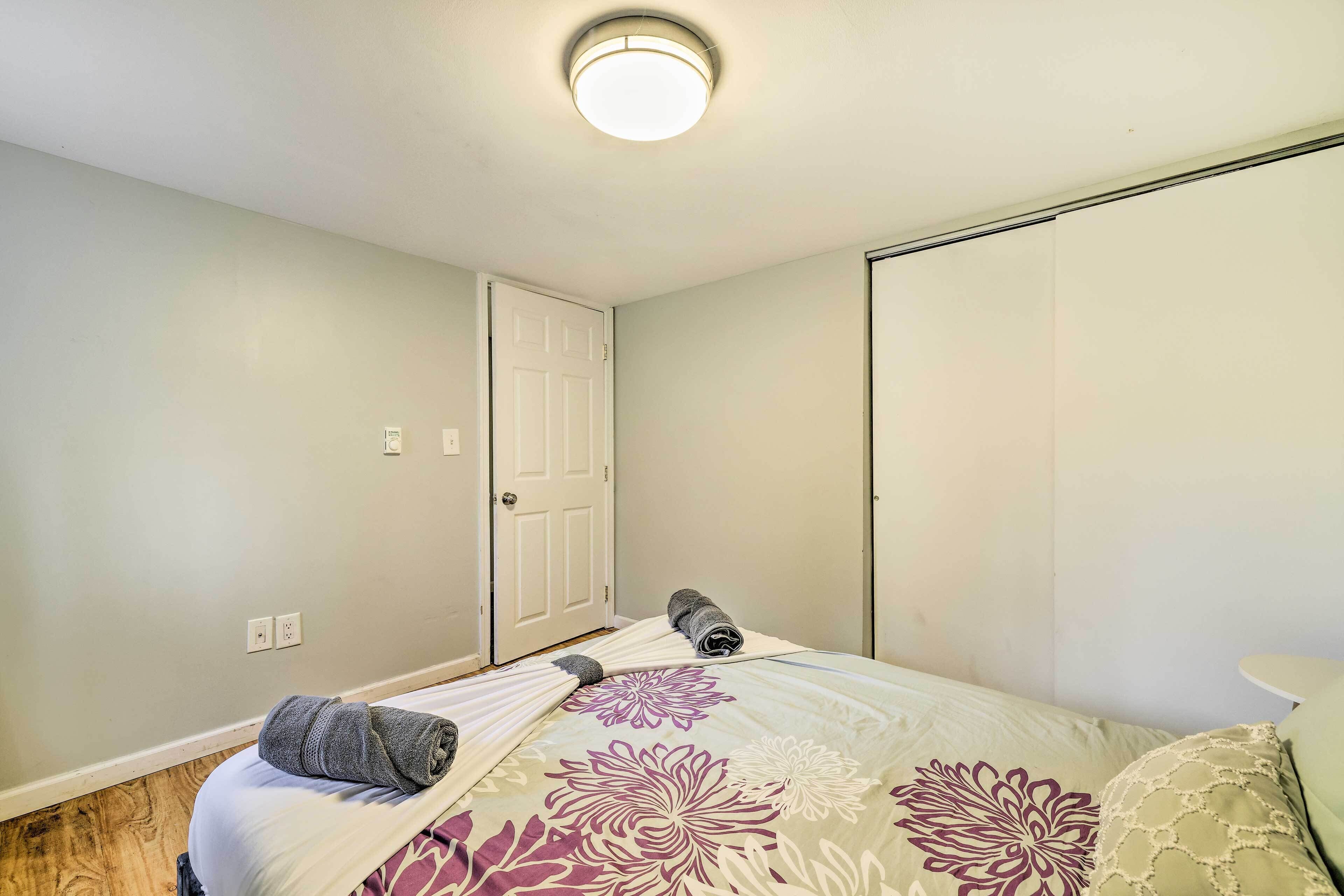 A bedroom with a bed, a door, and a closet.