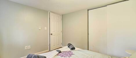 A bedroom with a bed, a door, and a closet.