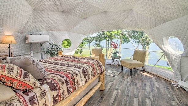 A cozy tent-style bedroom with a bed, seating area, and a view of the outdoors. - Big Lake Getaway w/ Private Beach + Fire Pit! (Cushing)