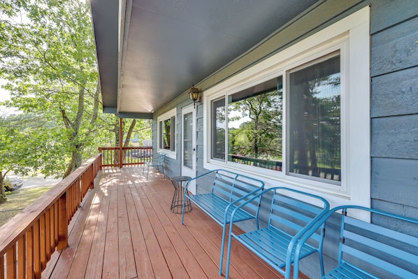 A wooden deck with blue metal benches and a small table, overlooking a green landscape. - 4 Mi to Dtwn! Ozarks Hideaway w/ Furnished Deck (Eureka Springs)