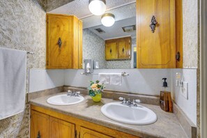 A bathroom with two sinks, wooden cabinets, a mirror, and a towel rack. - 4 Mi to Dtwn! Ozarks Hideaway w/ Furnished Deck (Eureka Springs)