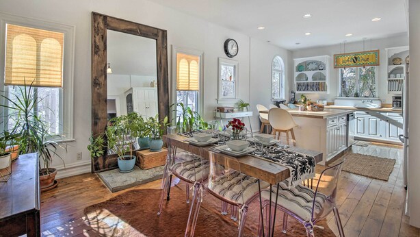 A spacious kitchen with white cabinets, a wooden dining table, and clear chairs. - Walk to Downtown: Pet-friendly Millerton Home! (Millerton)