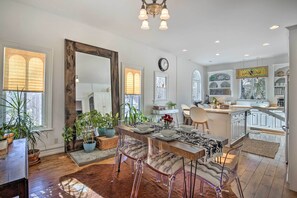 A spacious kitchen with white cabinets, a wooden dining table, and clear chairs. - Walk to Downtown: Pet-friendly Millerton Home! (Millerton)