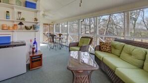 A sunlit room with a sofa, a table, and a kitchenette. - Lake Cumberland Resort Condo w/ Direct Lake Access (Bronston)