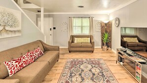 A living room with a brown sofa, a patterned rug, and a television on a stand. - Fort Worth Retreat w/ Fenced Yard & Fire Pit! (Fort Worth)