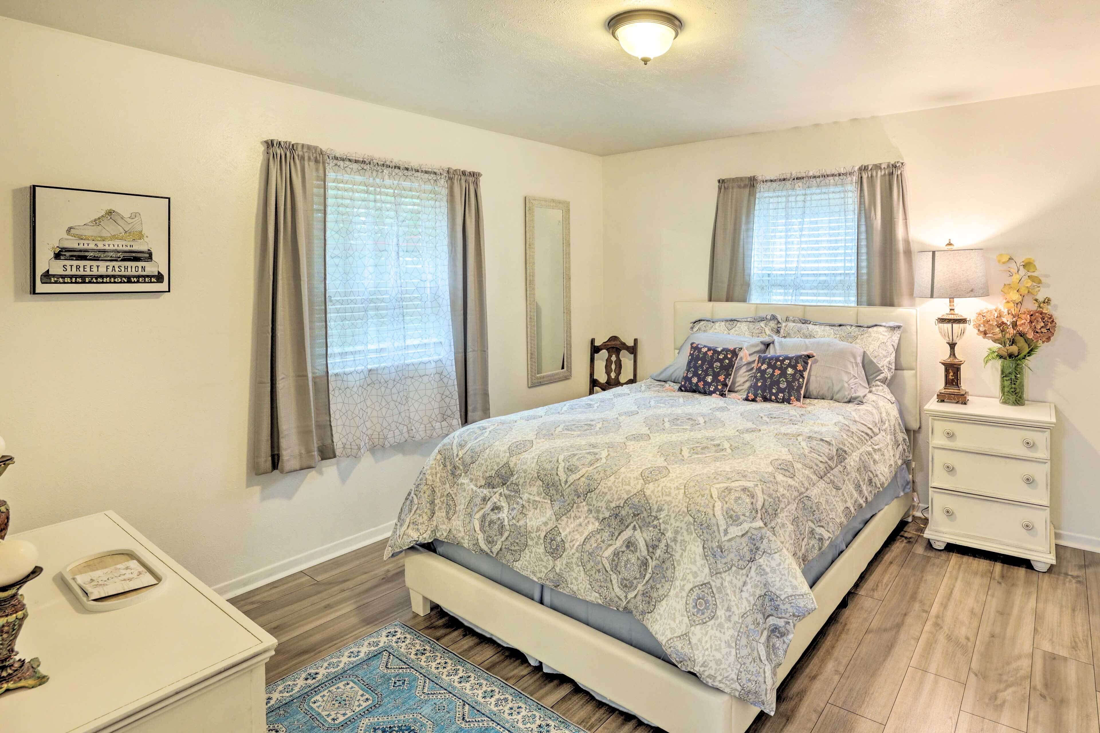 A bedroom with a bed, a nightstand, a lamp, and a decorative item on the nightstand.
