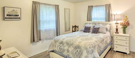 A bedroom with a bed, a nightstand, a lamp, and a decorative item on the nightstand.