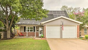 A two-story house with a garage, solar panels on the roof, and a well-maintained lawn. - Fort Worth Retreat w/ Fenced Yard & Fire Pit! (Fort Worth)
