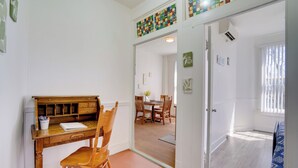 Ein Zimmer mit einem Holztisch, einem Stuhl und einem Essbereich mit Tisch und Stühlen.