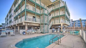 A multi-story hotel with a pool area, outdoor seating, and a fenced deck. - Oceanfront Gulf Shores Condo ~ 2 Mi to The Hangout (Gulf Shores)